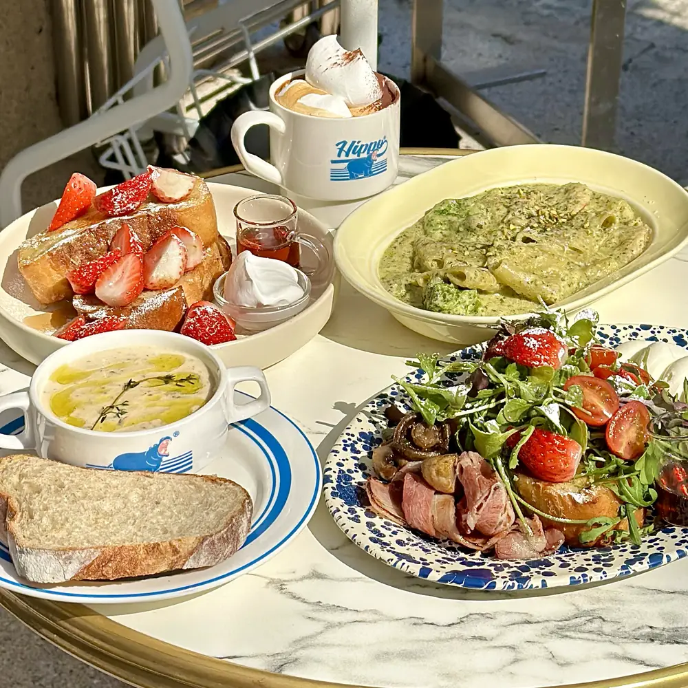 Strawberry French toast, basil cream paccheri, salad and a Hippo Vienna on the marble terrace table
