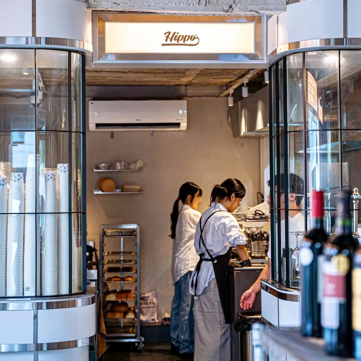 히포 로고 조명 아래 주방 카운터에서 브런치를 준비하는 히포 브런치하우스 직원들