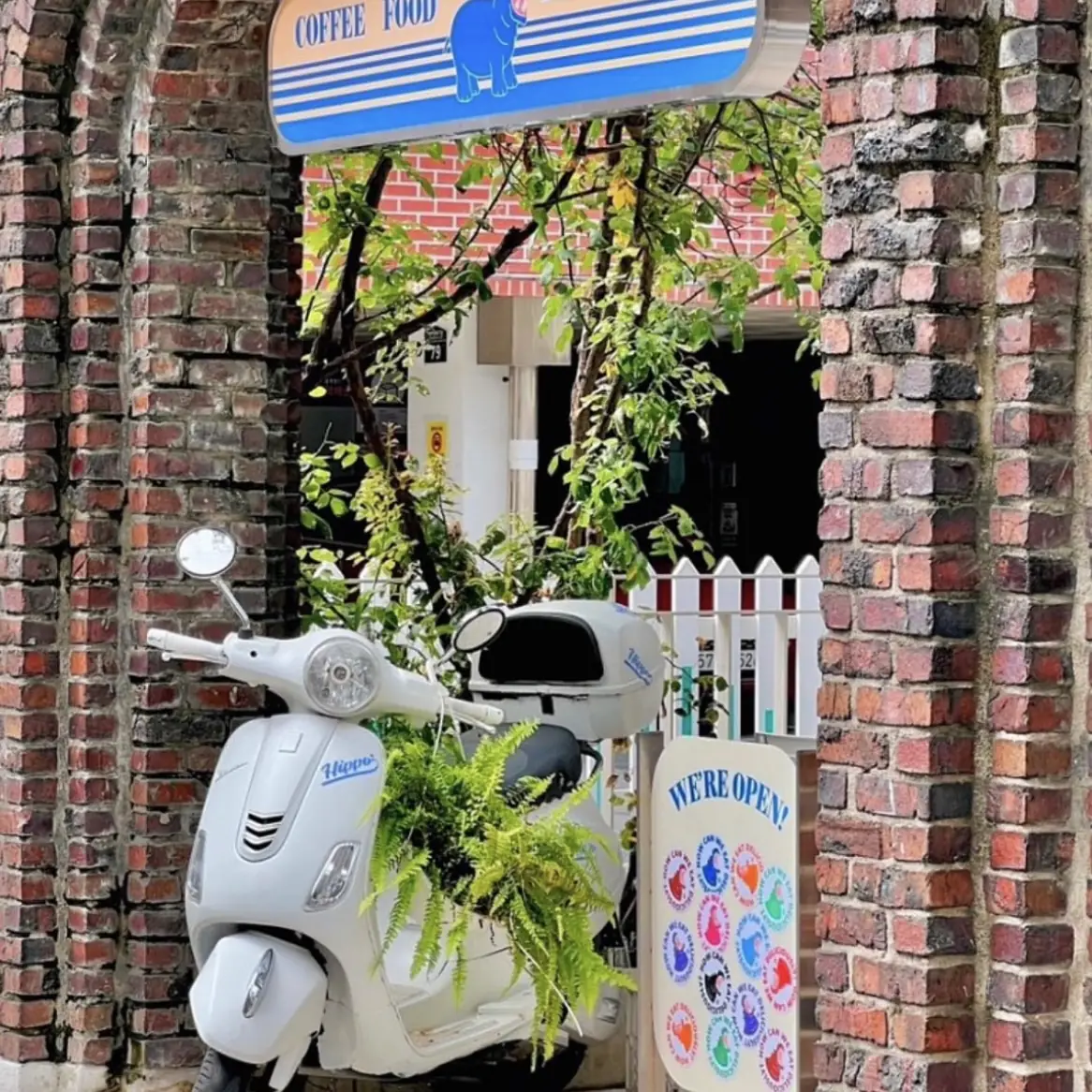 A white scooter under the brick archway entrance to Hippo Brunchaus, off Seongmisan-ro 17-gil